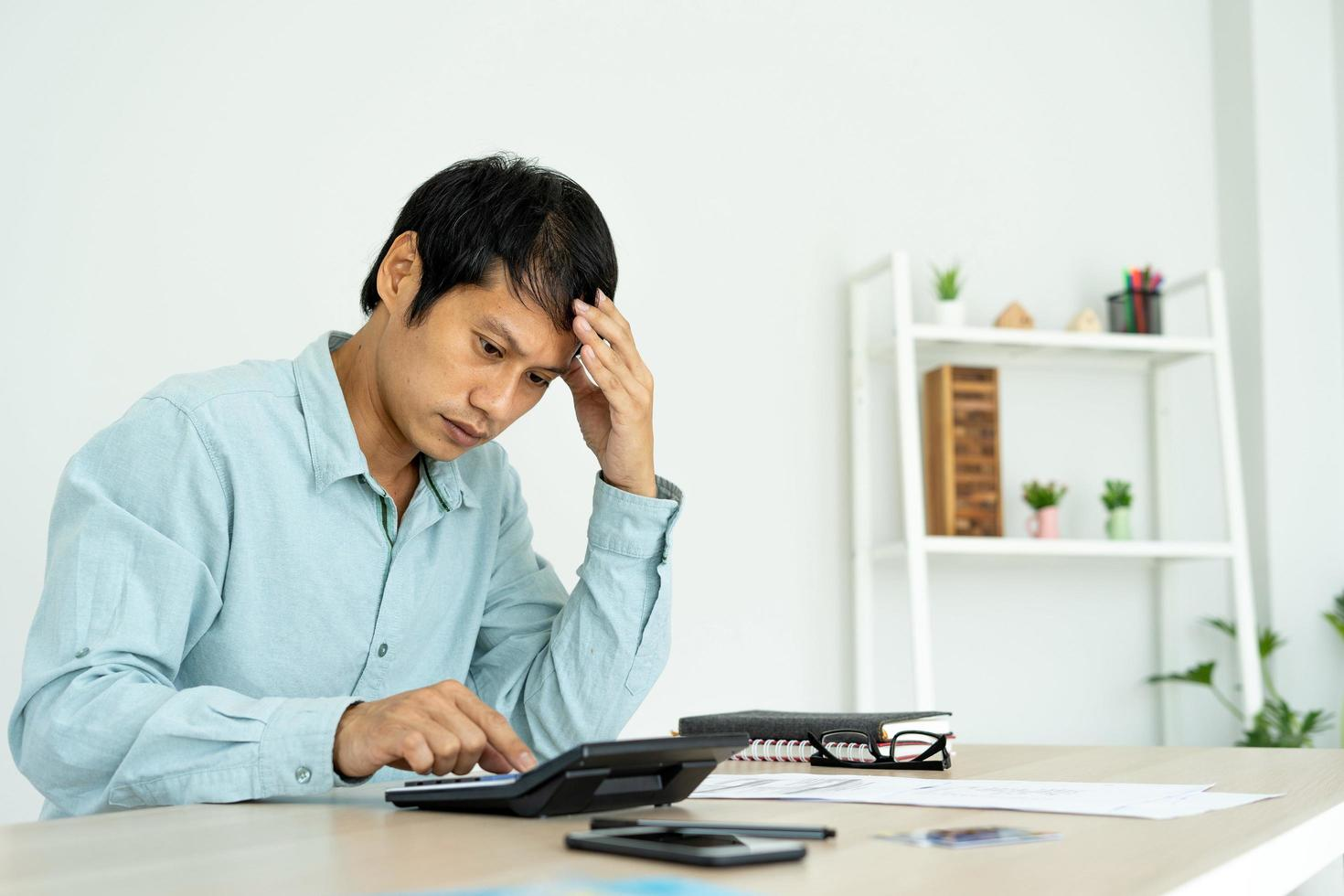 stressed man calculating his bills on the calculator
